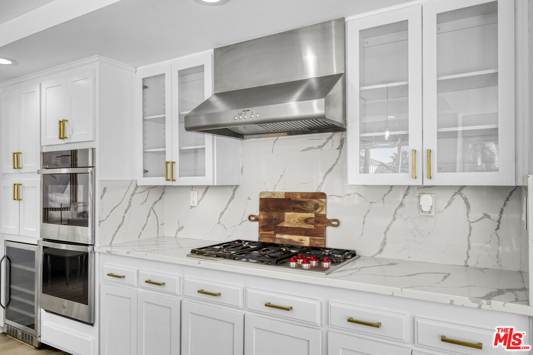 19668 Pine Valley Way Porter Ranch, CA 91326 - Photo 14 of 52 a kitchen with stainless steel appliances granite countertop a stove and a microwave