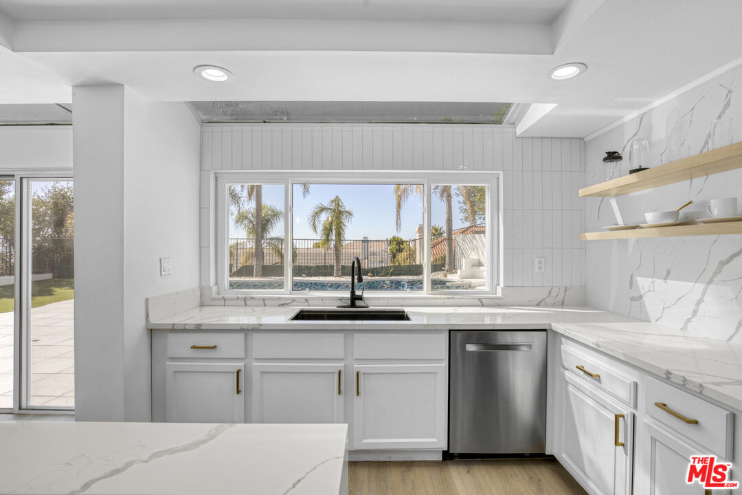 19668 Pine Valley Way Porter Ranch, CA 91326 - Photo 15 of 52 a kitchen with stainless steel appliances white cabinets and wooden floor