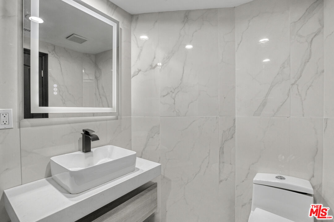19668 Pine Valley Way Porter Ranch, CA 91326 - Photo 22 of 52 a bathroom with a sink toilet and a mirror