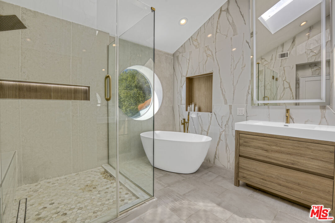 19668 Pine Valley Way Porter Ranch, CA 91326 - Photo 27 of 52 a spacious bathroom with a tub sink and mirror