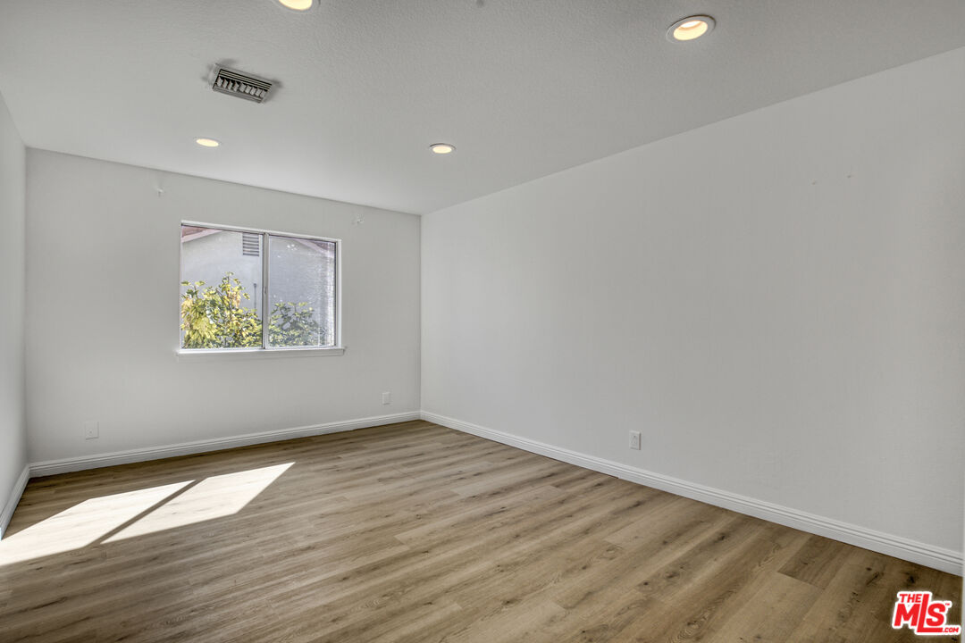 19668 Pine Valley Way Porter Ranch, CA 91326 - Photo 31 of 52 an empty room with wooden floor and windows