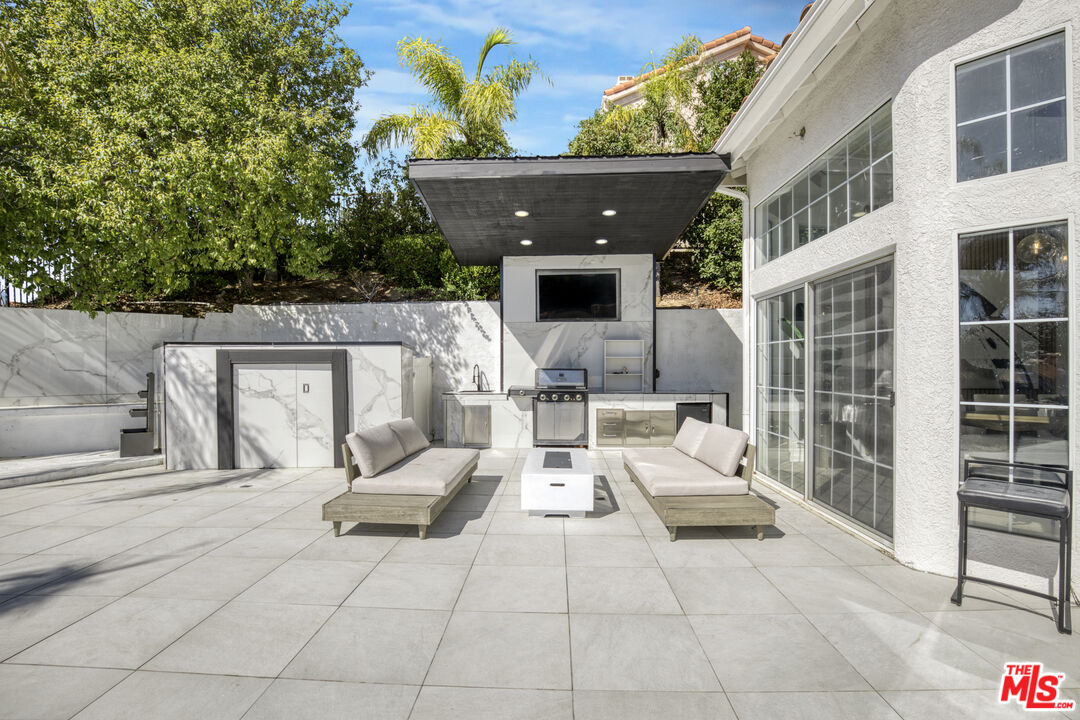 19668 Pine Valley Way Porter Ranch, CA 91326 - Photo 37 of 52 a view of a patio with couches and potted plants