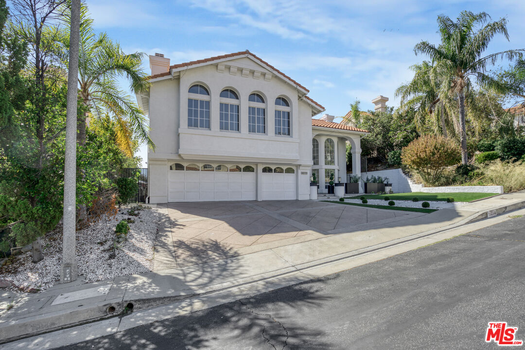 19668 Pine Valley Way Porter Ranch, CA 91326 - Photo 41 of 52 a front view of a house with a yard and garage