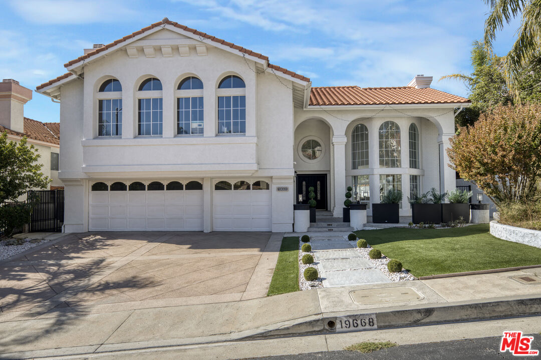 19668 Pine Valley Way Porter Ranch, CA 91326 - Photo 42 of 52 a view of a white house with garden in front of it