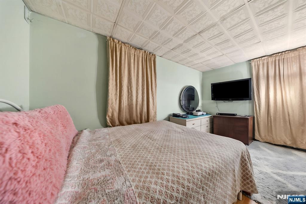 409 Hamilton Street Harrison, NJ 07029 - Photo 30 of 44 a bedroom with a bed tv and window