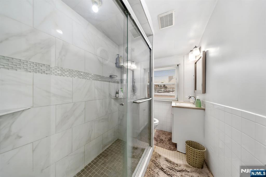 409 Hamilton Street Harrison, NJ 07029 - Photo 37 of 44 a bathroom with a mirror and shower