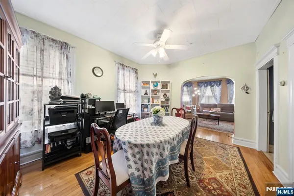 a kitchen with stainless steel appliances granite countertop a refrigerator a sink dishwasher a dining table and chairs with wooden floor
