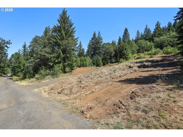 a view of a dirt road with a building in the background