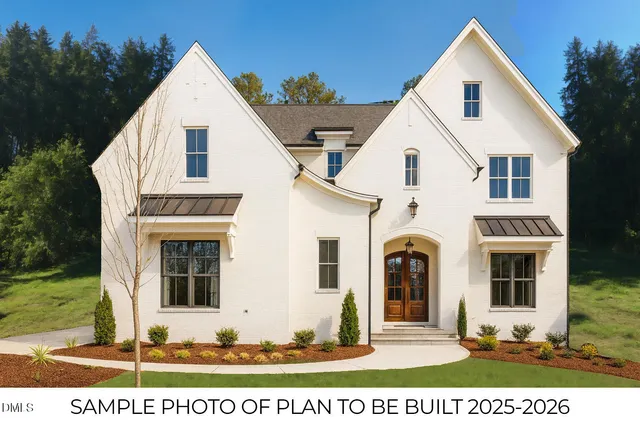 a view of a white house with large windows and yard