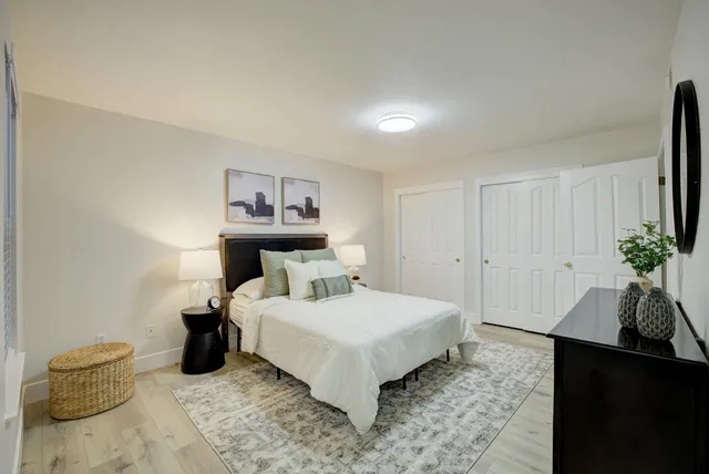 a bedroom with a bed and a potted plant