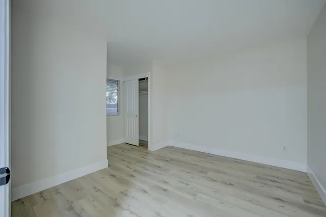a view of an empty room with wooden floor