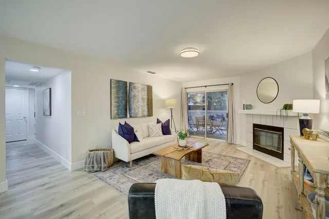 a living room with furniture a flat screen tv and a fireplace