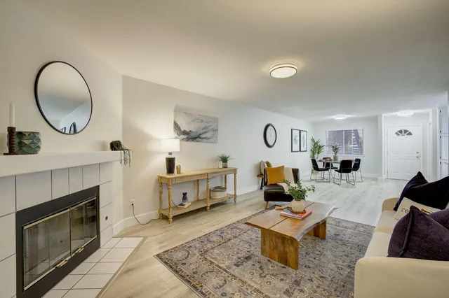 a living room with furniture a mirror and a fireplace