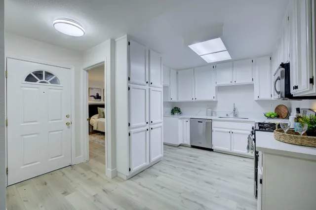 a kitchen with cabinets and wooden floor