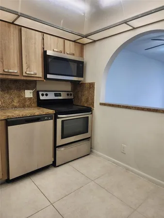 a kitchen with stainless steel appliances granite countertop a stove a microwave and a sink