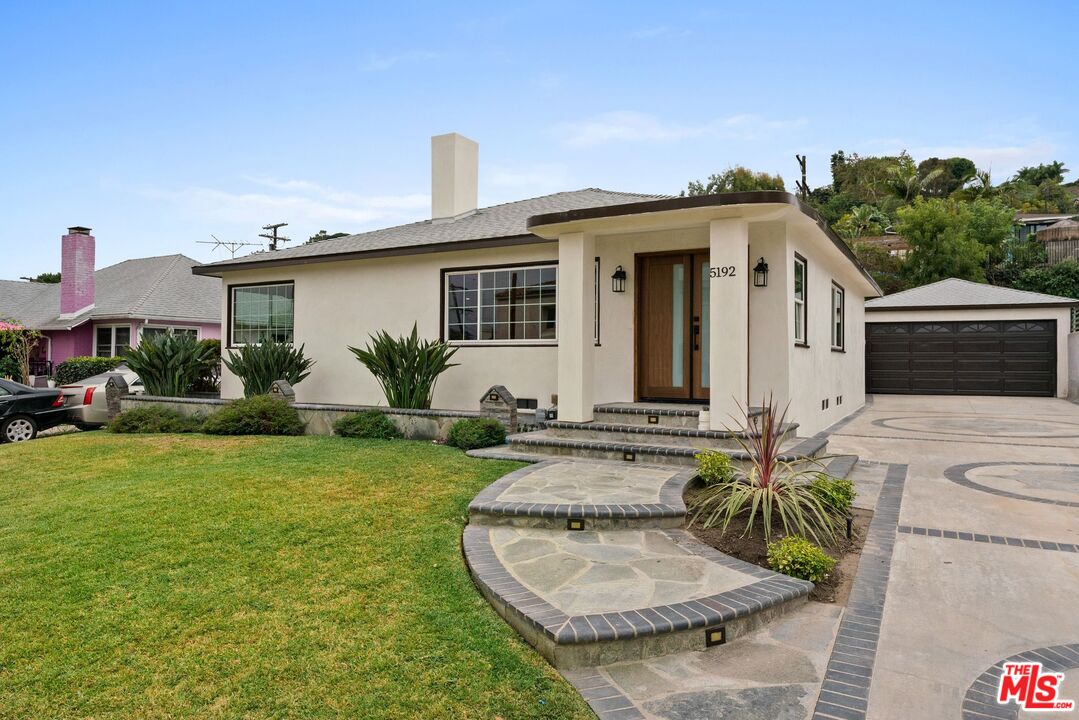 a view of a house with backyard and sitting area