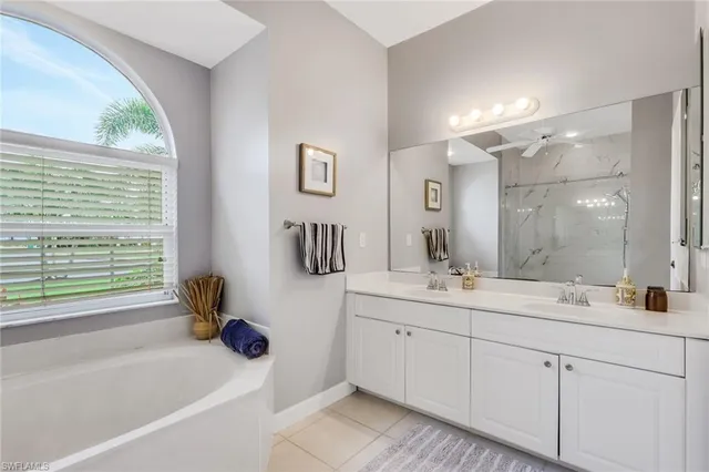 a bathroom with a double vanity sink toilet mirror and bathtub