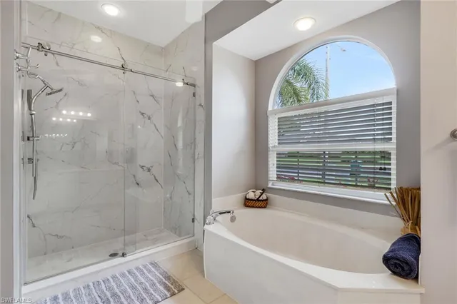 a bathroom with a tub a window and a shower