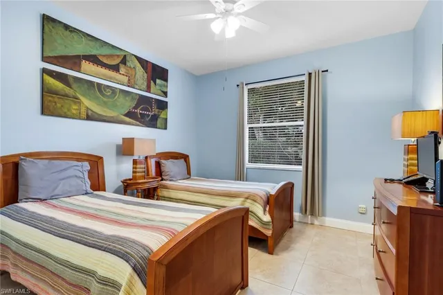 a bedroom with 2 bed and a window