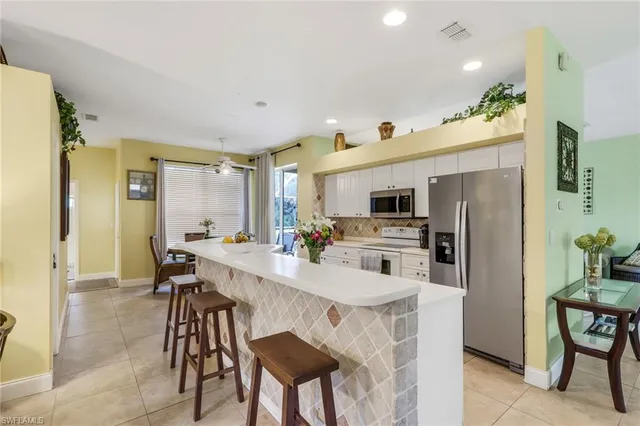 a kitchen with stainless steel appliances kitchen island granite countertop a refrigerator and a stove top oven