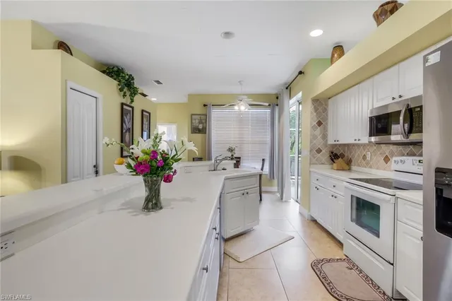 a kitchen with stainless steel appliances kitchen island granite countertop sink stove and refrigerator
