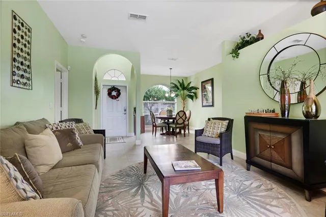 a living room with furniture a fireplace and wall paintings