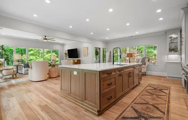 a view of a kitchen with sink refrigerator and natural light