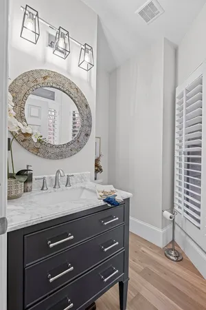 a bathroom with a toilet a sink a mirror a vanity and shower