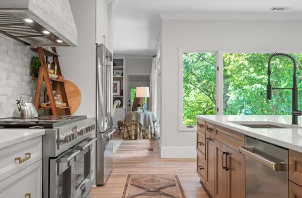 a kitchen with kitchen island granite countertop a sink and a stove top oven