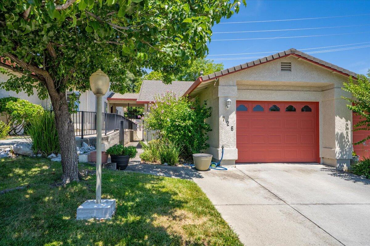 726 Stonebriar Trail Redding, CA 96003 - Photo 1 of 26 a front view of a house with a garden