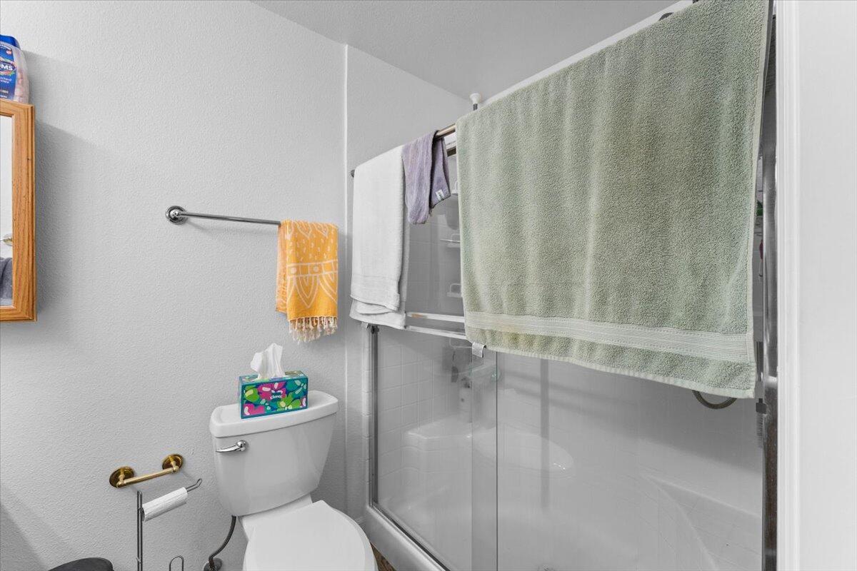 726 Stonebriar Trail Redding, CA 96003 - Photo 17 of 26 a white toilet sitting next to a shower curtain