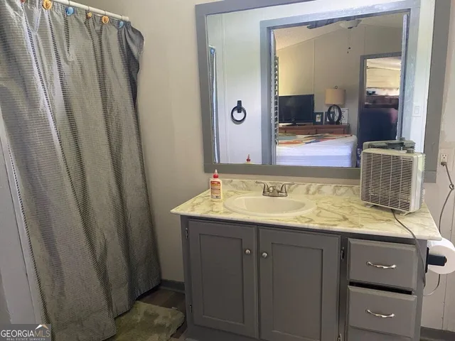 a bathroom with a granite countertop sink and a mirror