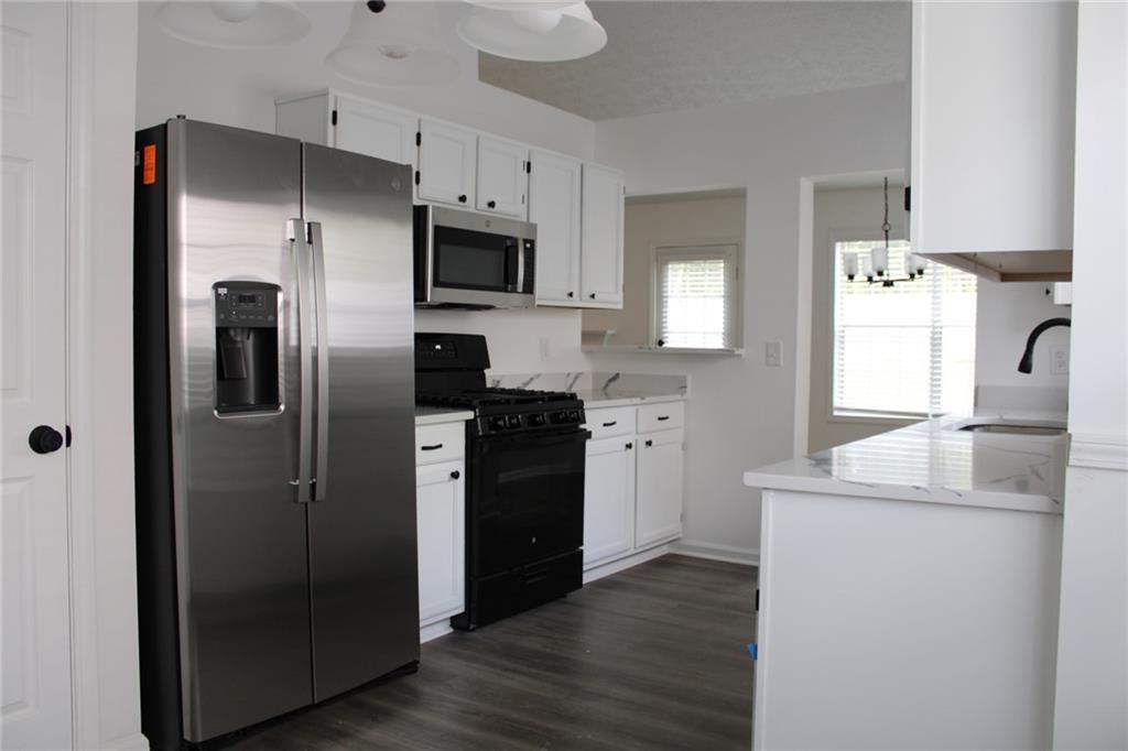 3389 Lochness Lane Powder Springs, GA 30127 - Photo 11 of 48 a kitchen with stainless steel appliances a refrigerator sink and microwave
