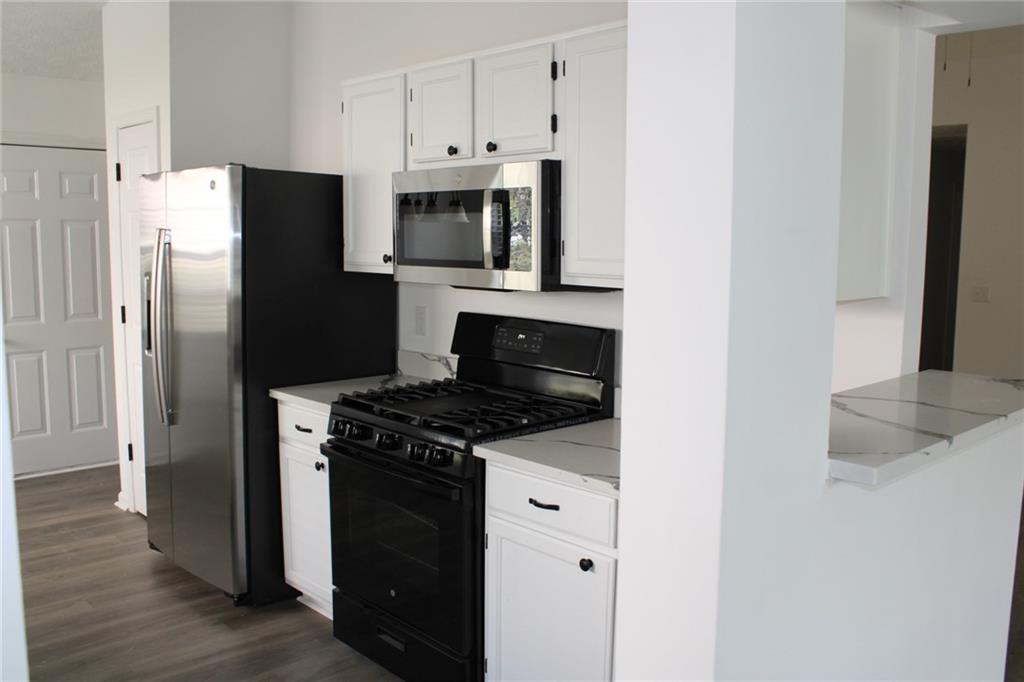 3389 Lochness Lane Powder Springs, GA 30127 - Photo 12 of 48 a kitchen with stainless steel appliances a stove a microwave and a refrigerator