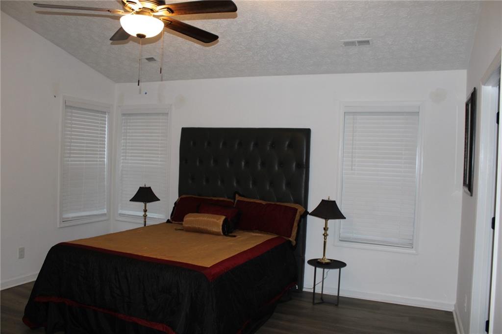 3389 Lochness Lane Powder Springs, GA 30127 - Photo 22 of 48 a bedroom with a bed and a chandelier