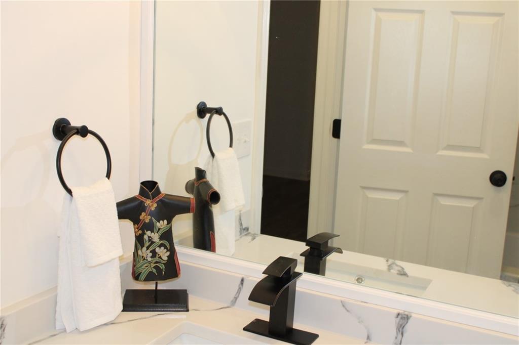 3389 Lochness Lane Powder Springs, GA 30127 - Photo 26 of 48 a bathroom with a tub sink and a mirror