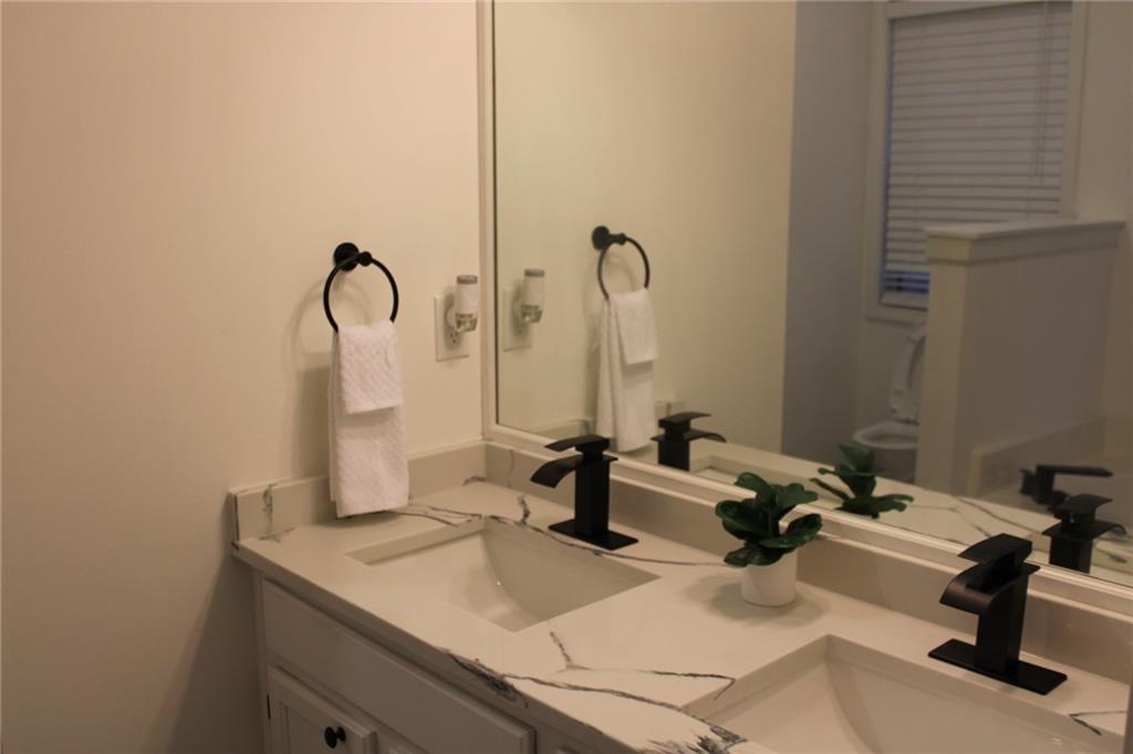 3389 Lochness Lane Powder Springs, GA 30127 - Photo 27 of 48 a bathroom with a sink and a mirror