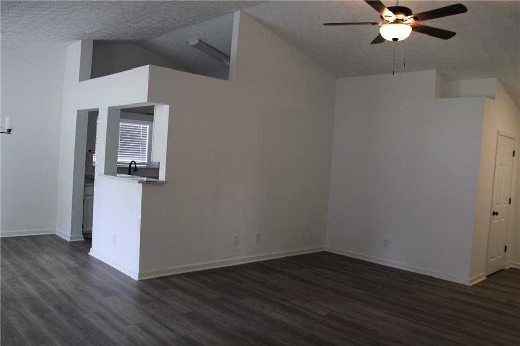 3389 Lochness Lane Powder Springs, GA 30127 - Photo 36 of 48 a view of a livingroom with wooden floor and a ceiling fan