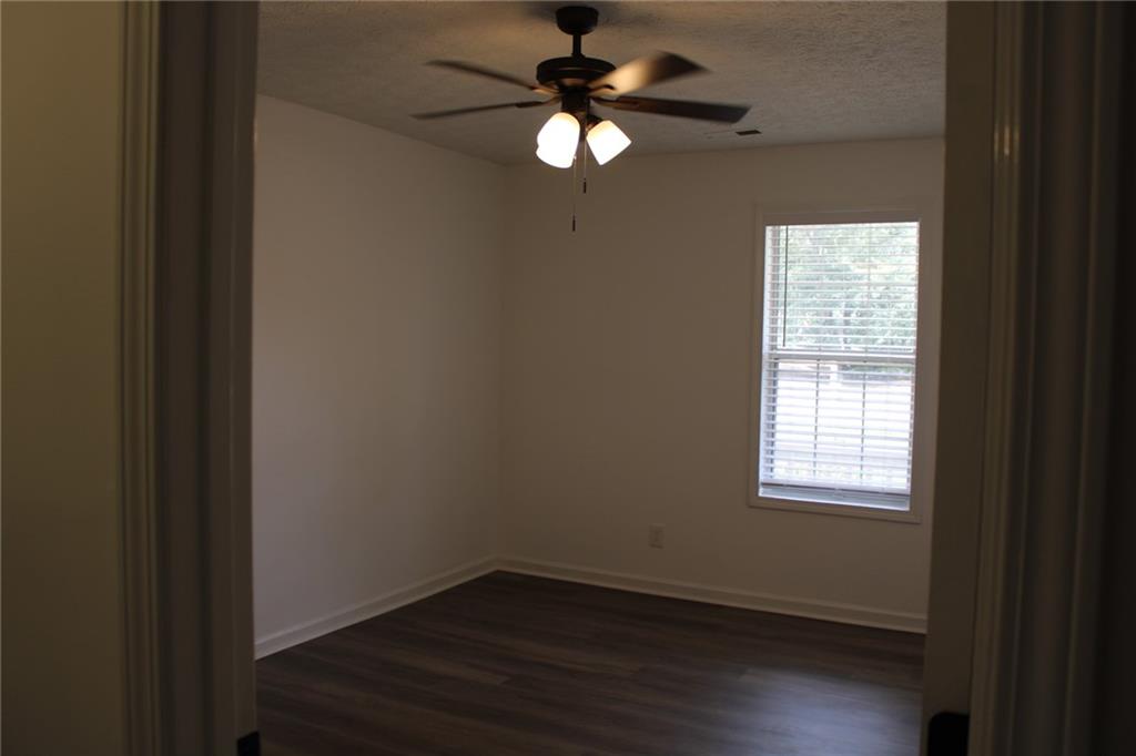 3389 Lochness Lane Powder Springs, GA 30127 - Photo 41 of 48 a view of an empty room with wooden floor and a window