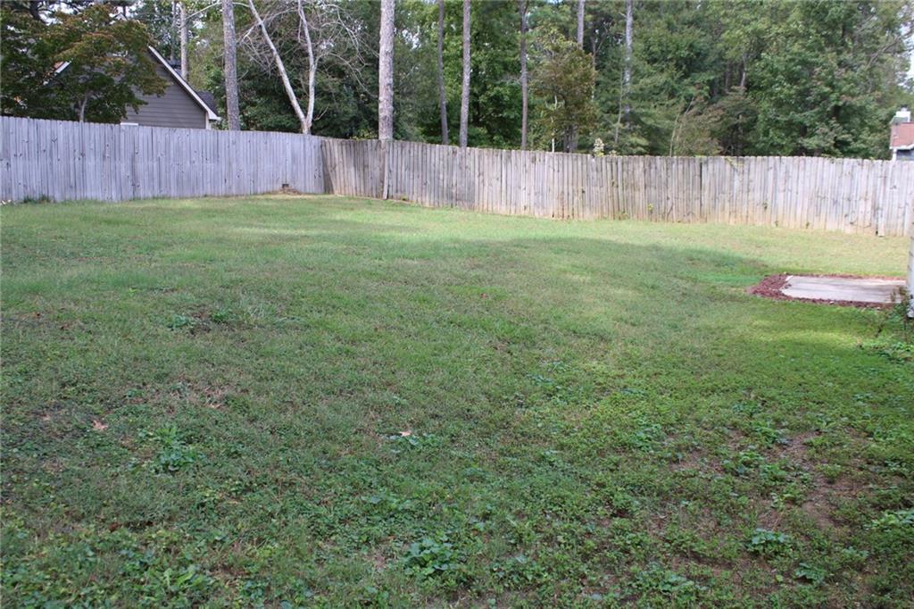 3389 Lochness Lane Powder Springs, GA 30127 - Photo 42 of 48 a view of a backyard with a fence and trees