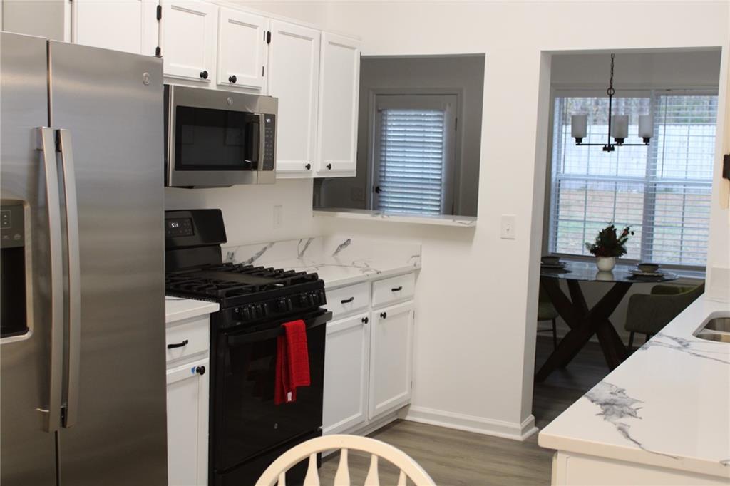 3389 Lochness Lane Powder Springs, GA 30127 - Photo 5 of 48 a kitchen with stainless steel appliances a stove a sink a refrigerator and a microwave