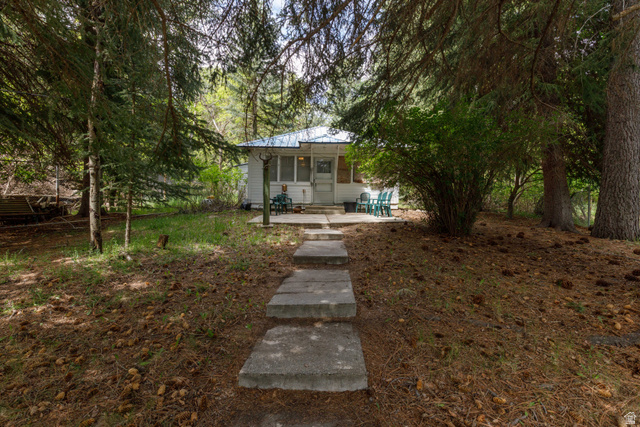 Concrete paver path leading to a white exterior residence