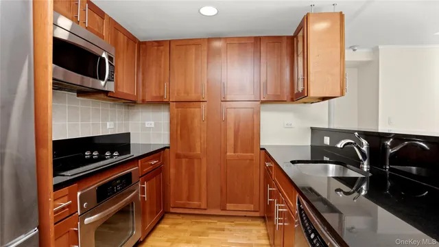 a kitchen with stainless steel appliances granite countertop a stove a microwave and a sink