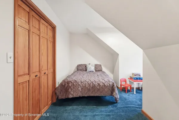 a view of a hallway with wooden floor and a living room
