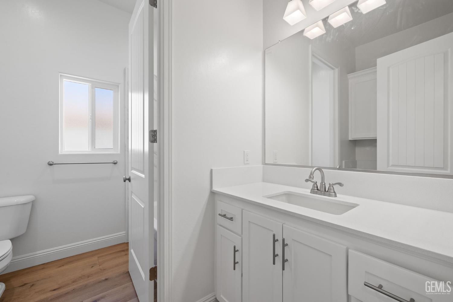 Undisclosed Address Bakersfield, CA 93314 - Photo 35 of 43 a bathroom with a toilet a sink a mirror and vanity