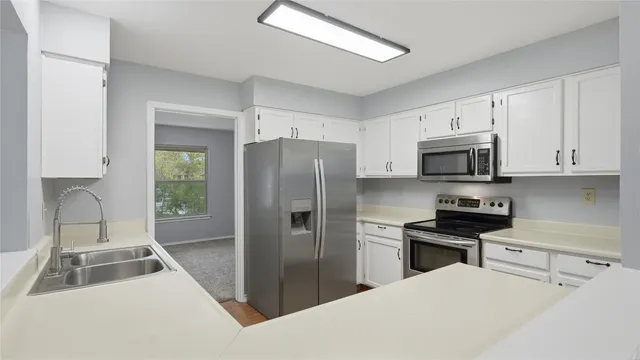 a kitchen with stainless steel appliances a refrigerator sink and microwave