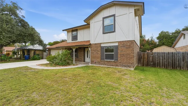 a view of a house with backyard and sitting area