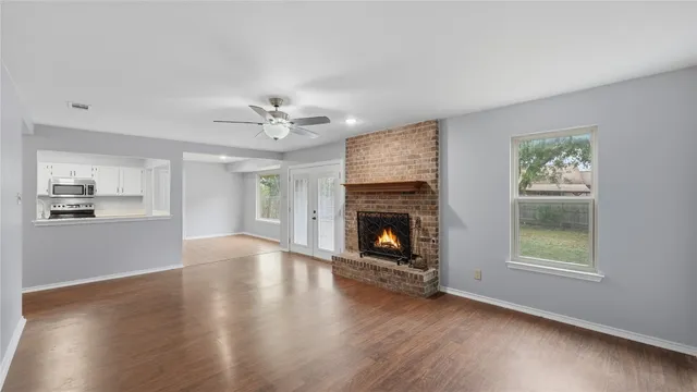 an empty room with windows and a fireplace