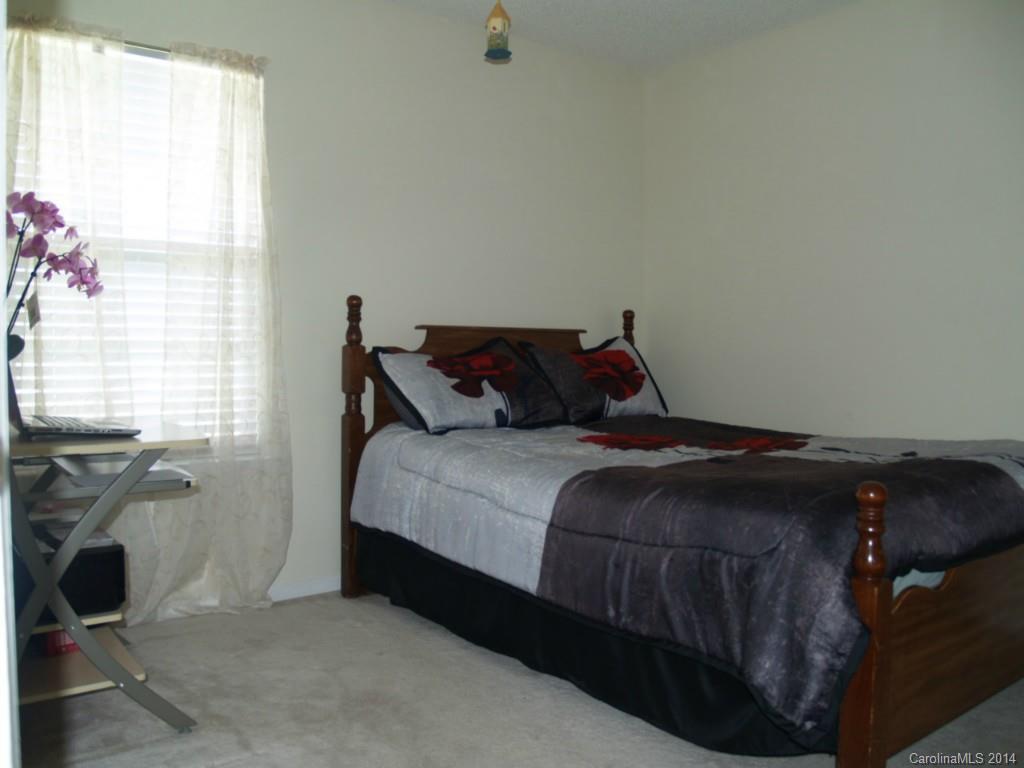 10402 Gold Pan Road Charlotte, NC 28215 - Photo 12 of 21 a bed sitting in a bedroom next to a window