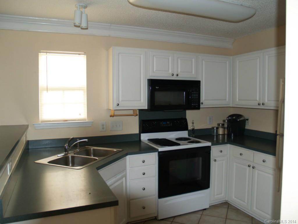10402 Gold Pan Road Charlotte, NC 28215 - Photo 5 of 21 a kitchen with granite countertop a sink stove and microwave